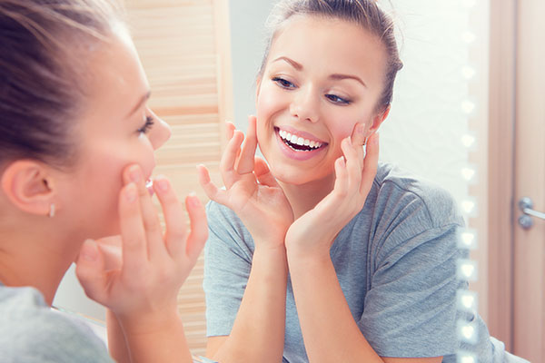 woman appreciating smile after teeth whitening